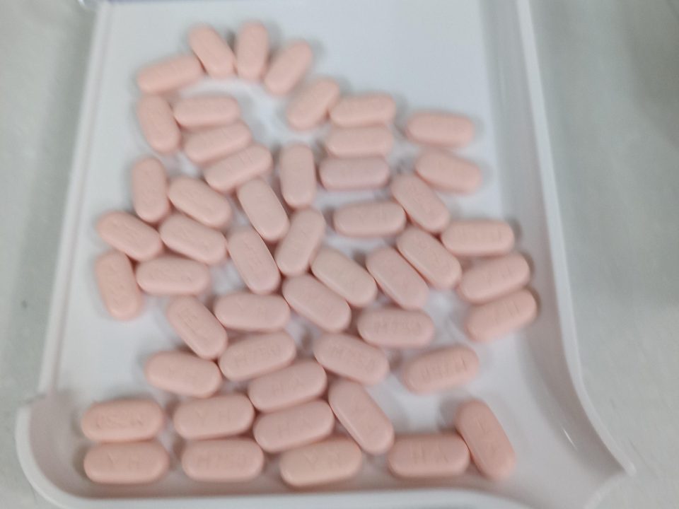 A saved count: 50 pink tablets on a white tray, each outlined and numbered.